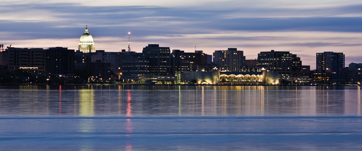 Nighttime view of downtown Madison skyline with Lake Monona in the foreground