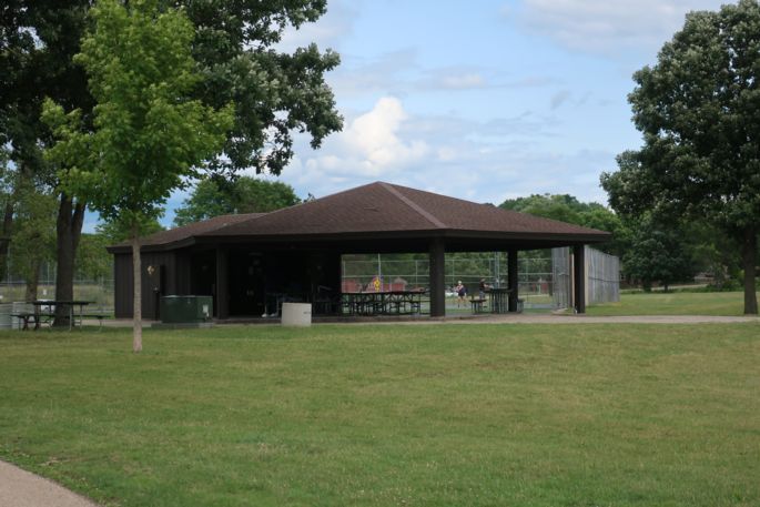Park shelter with grassy area and trees.