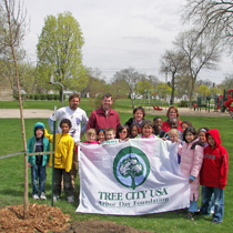 A group and their freshly planted tree on Arbor Day