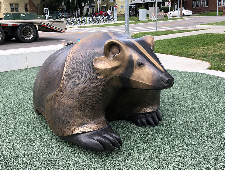 A metal badger placed on a green playground surface.