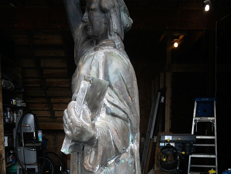 Replica Statue of Liberty in a workspace being restored.
