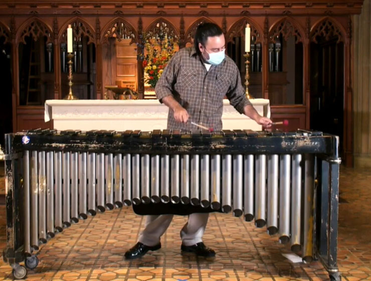 Eric De Los Santos playing bells in an ornate room.