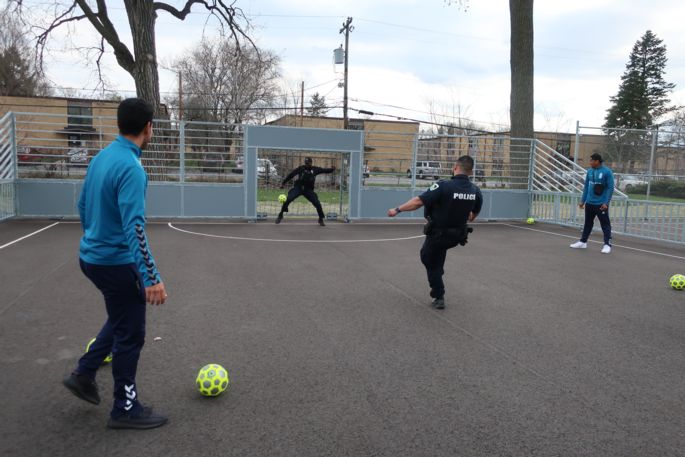 futsal court with people kicking balls to goal