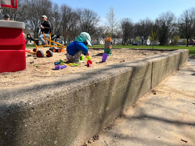 sand box with toys and children