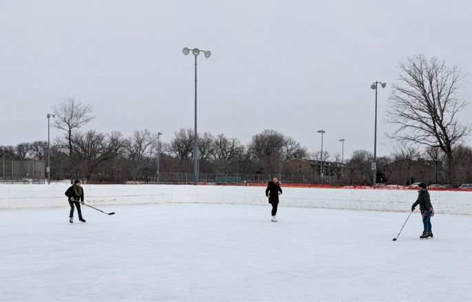 tenney park hockey rink with three players