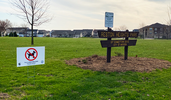 Reston Heights Park sign with a sign to the left stating that dogs are prohibited.