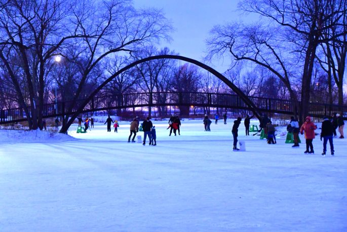 ice skaters on the frozen lagoon at Tenney Park in evening
