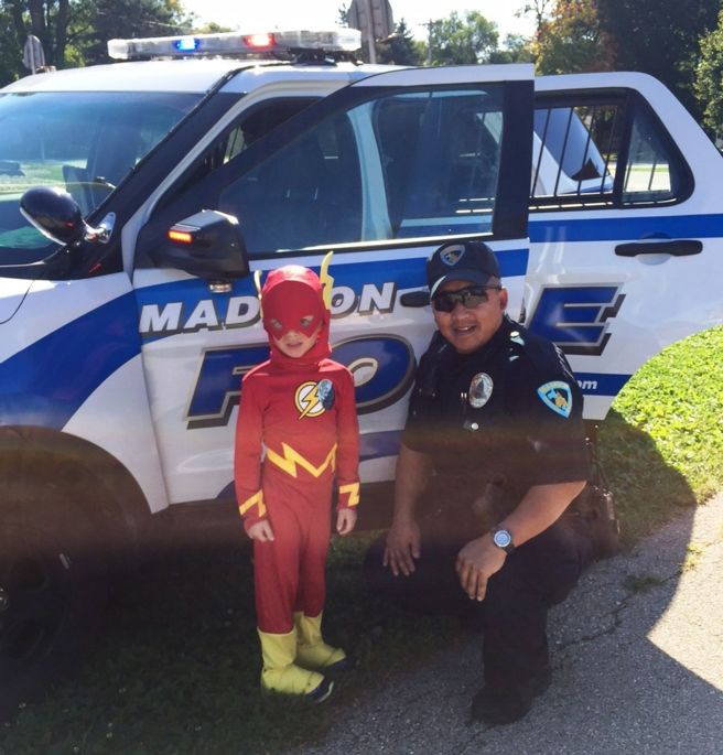 Officer Thai Xiong pictured with child dressed as superhero the Flash