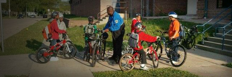 Officer helping children with bikes