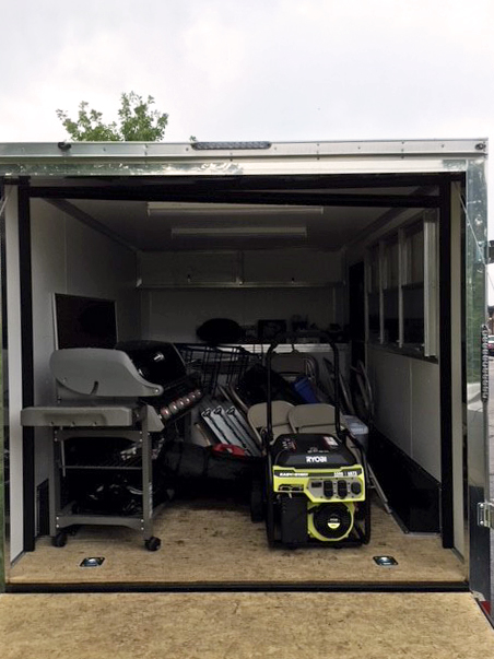 Neighborhood Resource Trailer with back door open showing grill, generator and other supplies.