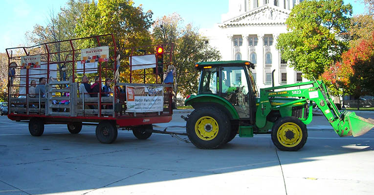 haywagon pulled by a green tractor in the street on the Capitol Square