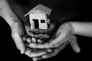 Hands holding small home.