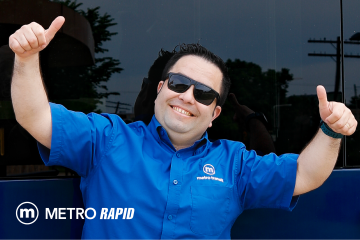 Smiling Metro driver holding both thumbs up