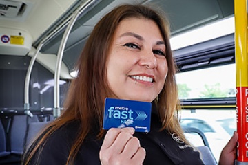 Metro driver holding a Fast Fare card