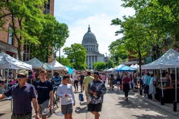 Street event with vendors and tents and people walking in the street