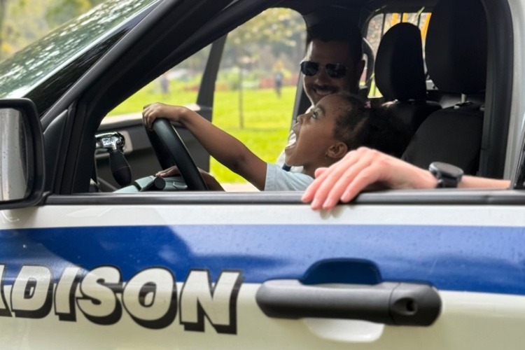 Child receives a tour of a squad car during a National Night Out celebration.