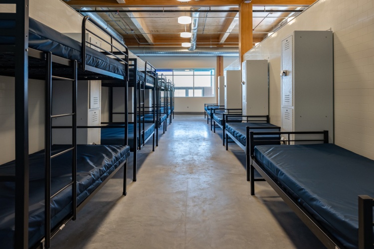 Sleeping area with a mix of bunk beds and single beds at the men's shelter
