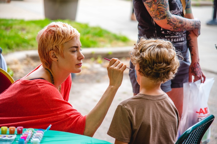 Child gets their face painted. 