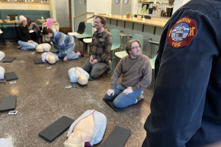 A paramedic oversees a hands-only CPR class
