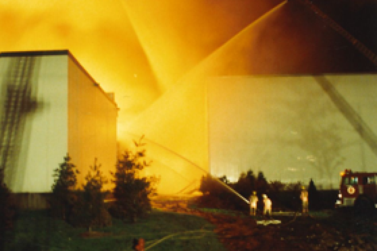 Two aerial streams and one handheld stream pointed at two freezer buildings