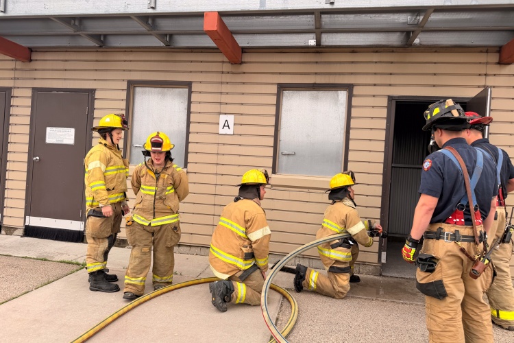 Medical intern prepares to enter a smoky room with hose