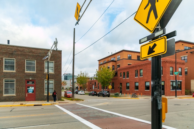 Person with white cane crossing Williamson St using Rectangular Rapid Flashing Beacon (RRFB)