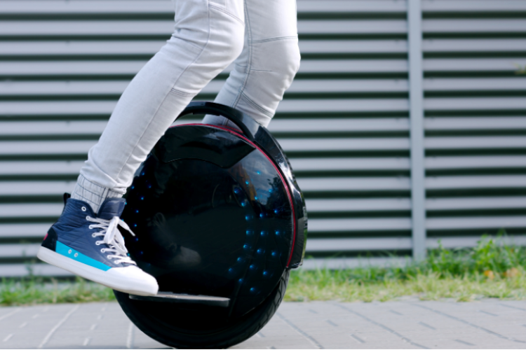 Person riding an electric unicycle on a paved path.