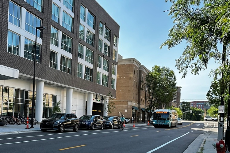 Metro Transit bus and bicyclist pass by new State Street Campus Garage, Lake Street, facility.