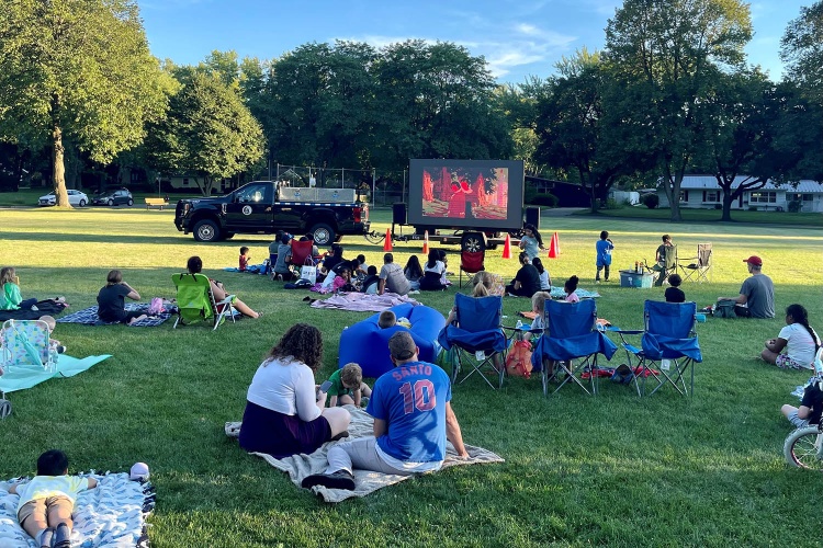people seated watching a movie in a park