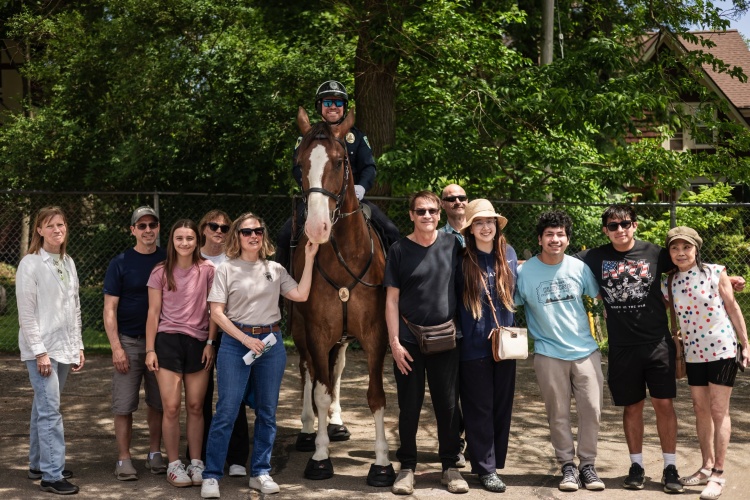 Buckets a horse on the mounted patrol unit is surrounded by family members of his sponsor.