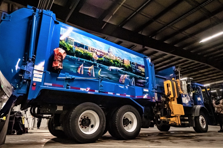 A low angle looking up a the mural truck featuring the Madison skyline from Lake Mendota