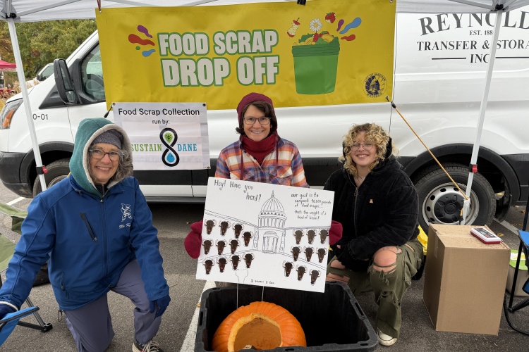 Sustain Dane folks who staffed the November 1, 2025 market pose with the bison poster.