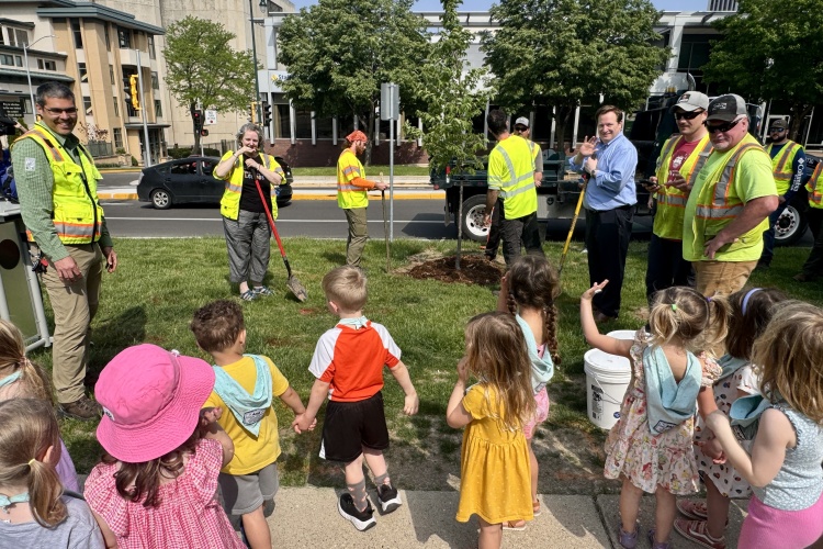 Kids look on as Mayor Satya Rhodes-Conway, Alder Mike Verveer, City Forester Ian Brown and City Forestry staff plant an elm tree. 