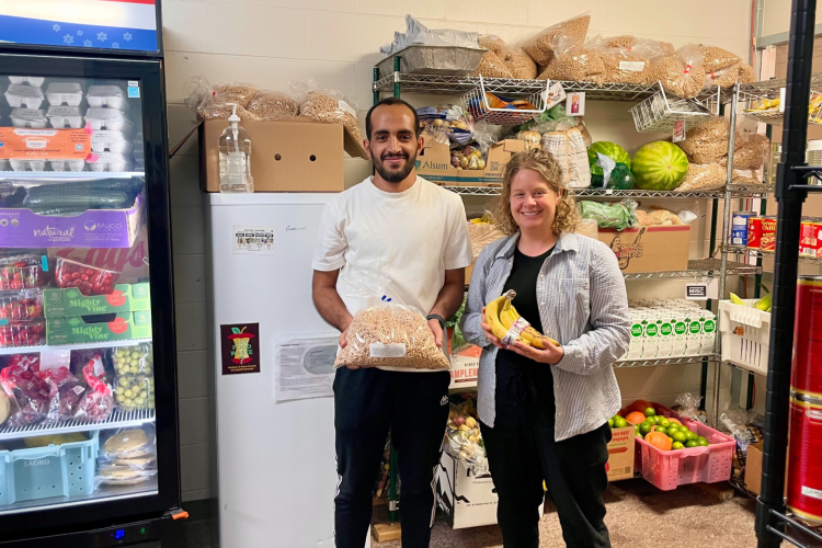 People pose with food at the Neighborhood House Food Pantry