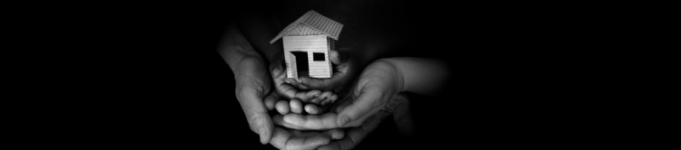 Hands holding a small home. 