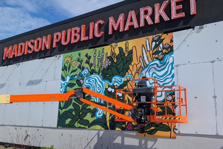 Mural being installed on the exterior of the Madison Public Market