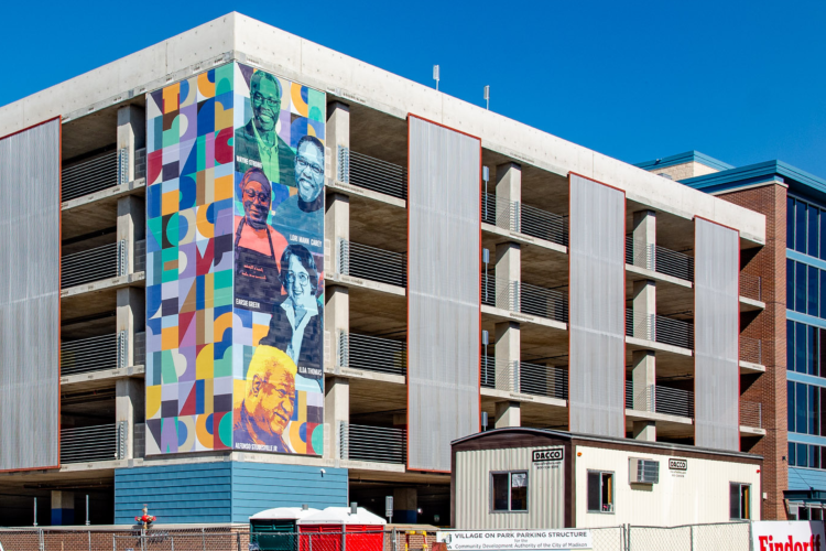 A mural on the new Village on Park parking structure shows the portraits of 5 prominent South Madison leaders
