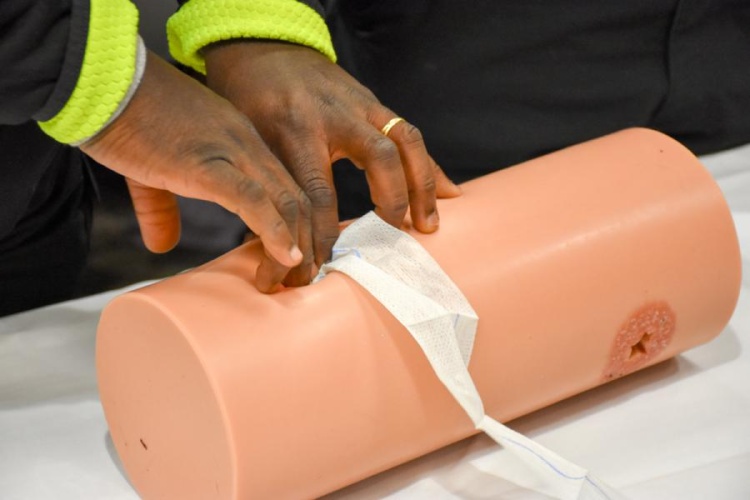 Applying wound dressing to fake wound