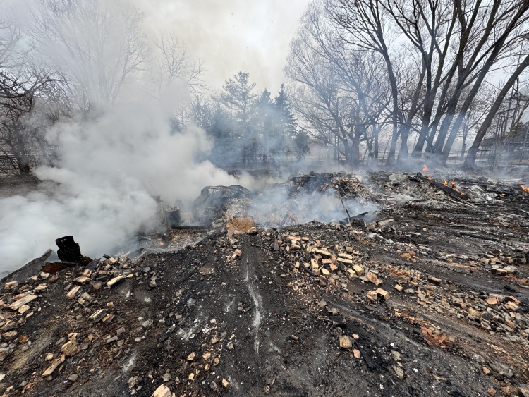 Smoke rises from the rubble pile where the house once stood