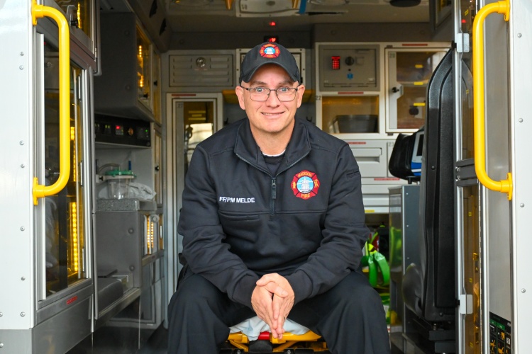 Firefighter/Paramedic Steve Melde seated in the back of an ambulance