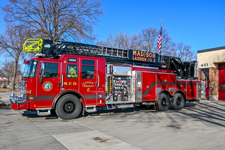 Firefighters stand in front of the ladder truck on display outside Station 2