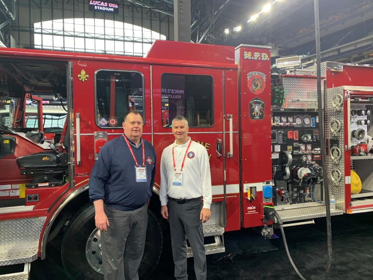 Scott Bavery stands with retired Fire Chief Steven Davis in front of the Volterra electric engine