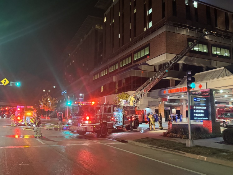 An aerial ladder extends to the 5th floor with firefighters on scene
