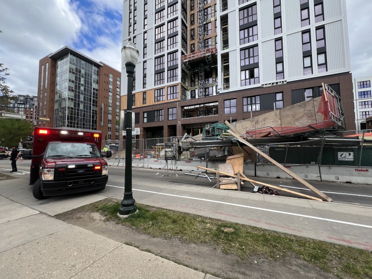 An ambulance with lights flashing situated next to the construction site