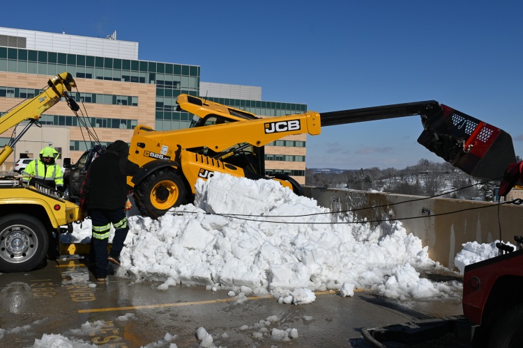 The telehandler is pulled back onto the proper side of the wall, onto a pile of snow