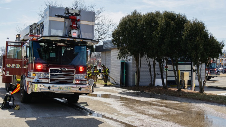 Ladder 2 next to the car wash building with firefighters in between