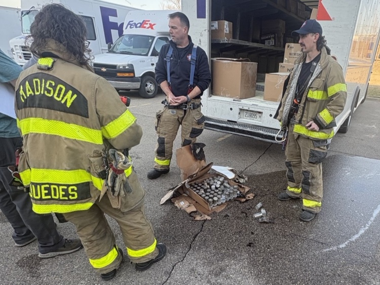 firefighters stand around a box of lithium ion battery cells