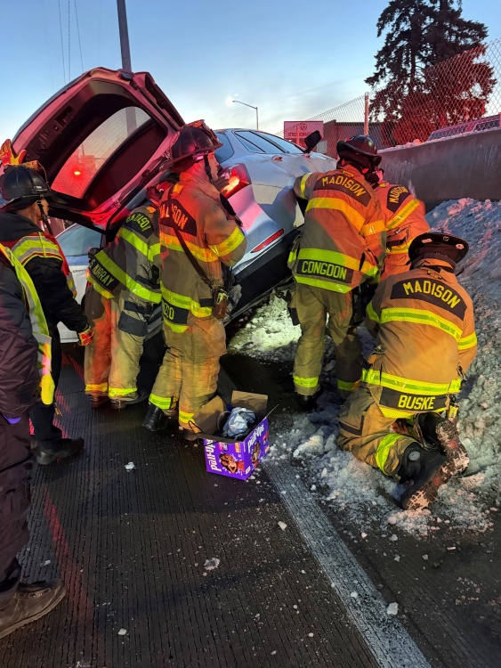 Medic 6 and Ladder 2 prepare to remove patient out of open hatchback of SUV