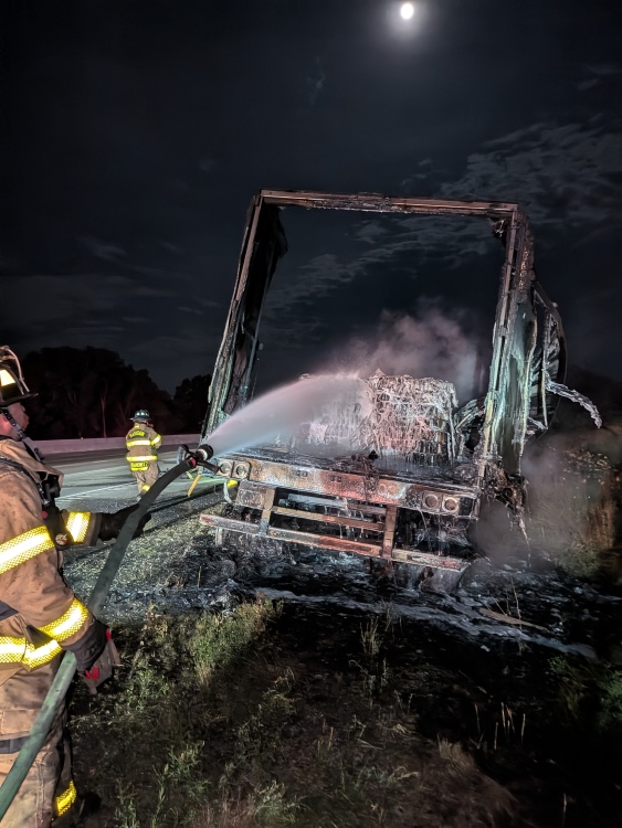 Firefighter sprays water into cargo trailer