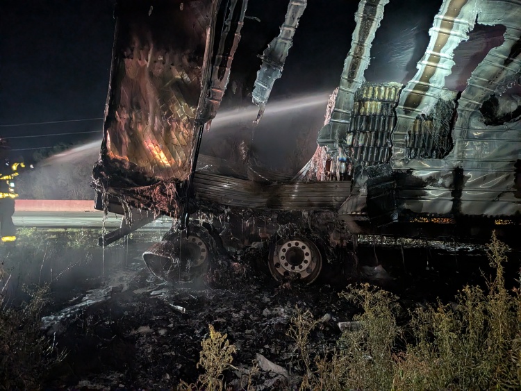 A damaged trailer and contents with a stream of water passing through
